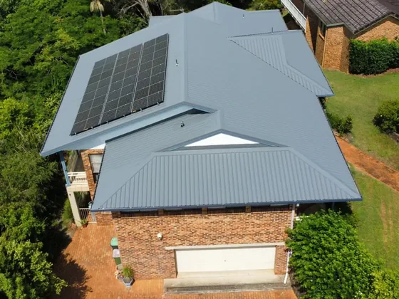 Aerial view of a metal roof with solar panels and new guttering on a brick two-storey home