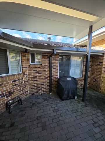 New continuous guttering on a brick home with a paved patio