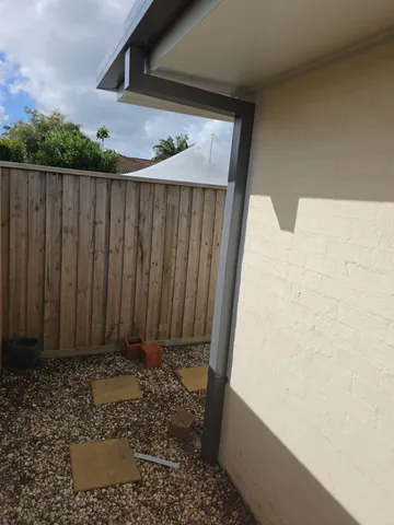 New downpipe and continuous guttering on a rendered wall