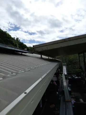 Gutter guard mesh over the gutter on a metal roof edge