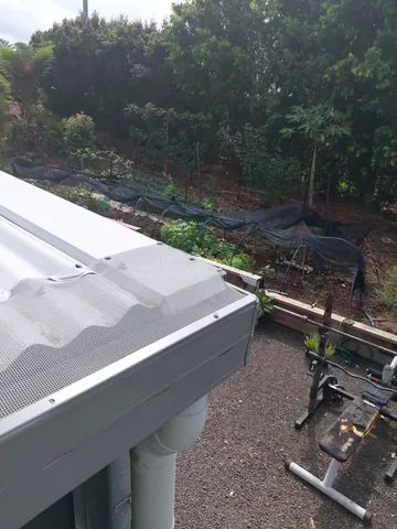 Gutter guard mesh fitted over a new gutter and downpipe
